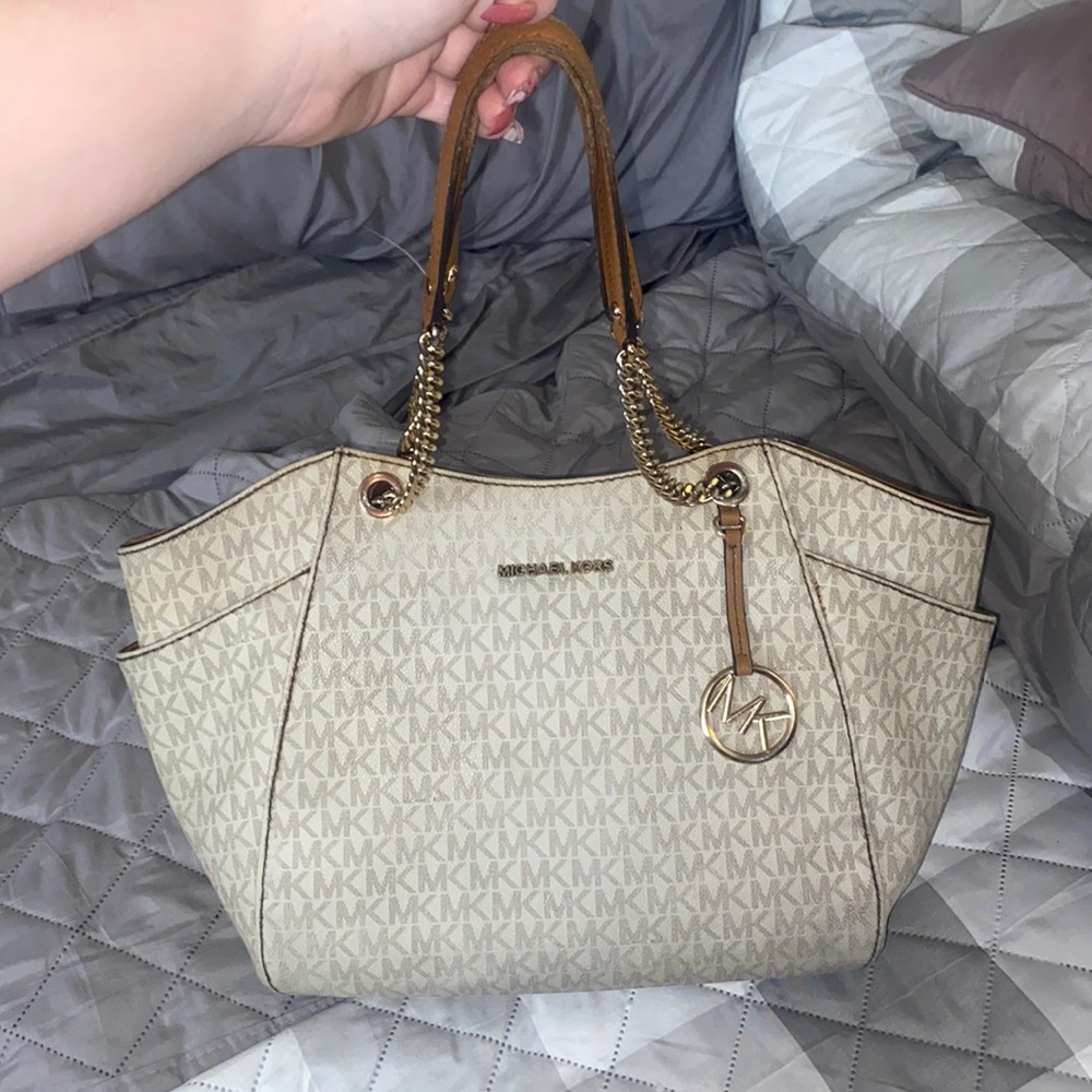 Cream colored tote bag. Gold chain handle